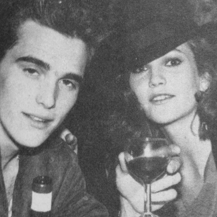 black and white photo of man and woman holding wine glass in front of their face