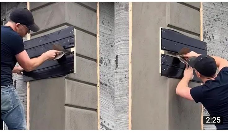 two men are working on the side of a building, one is holding a tool