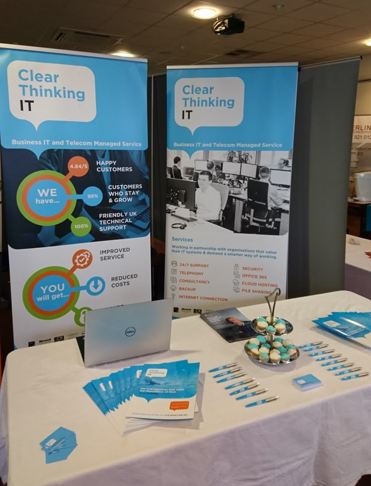 the table is set up for an event with signs on it and laptops in front of them