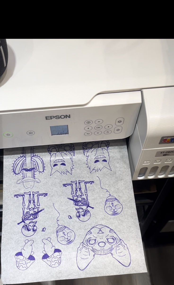 an epson printer with some drawings on it's paper in front of the printer