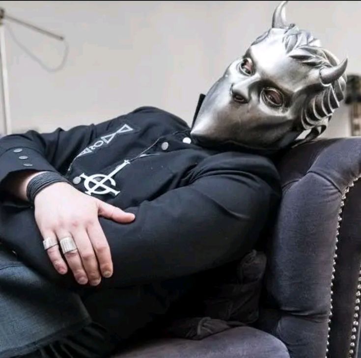 a man wearing a mask sitting on top of a couch