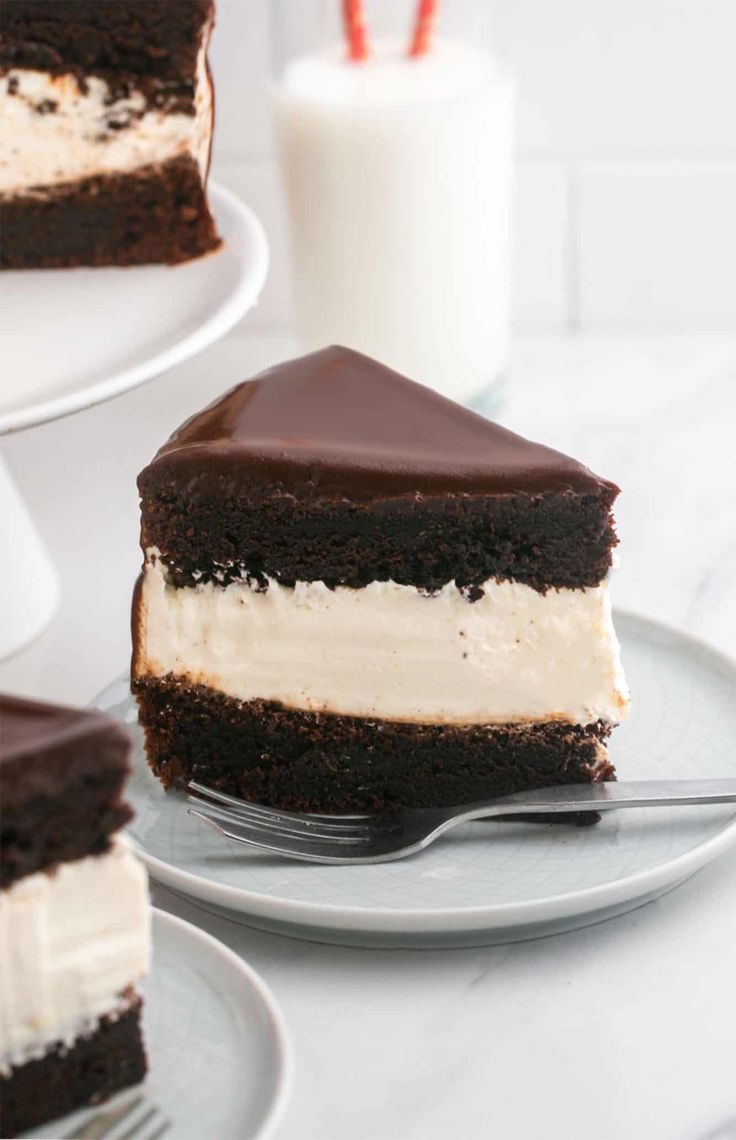 a piece of cake on a plate with a fork and milkshake in the background