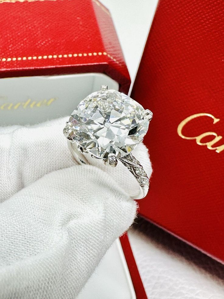 a close up of a diamond ring in a red box with the word cartier on it