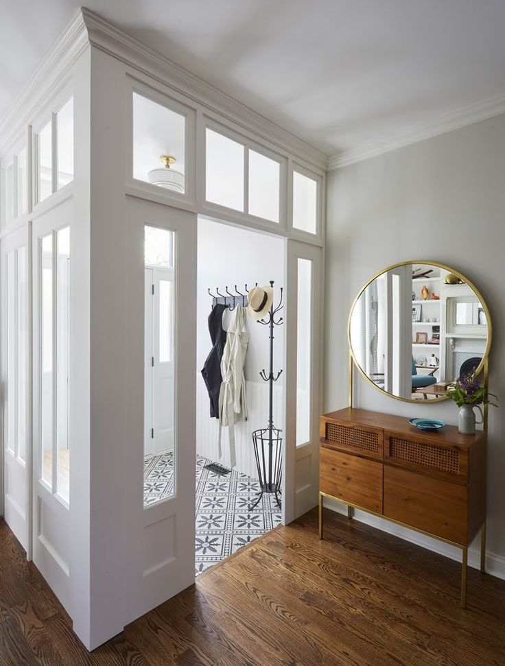 an entry way with a mirror and coat rack