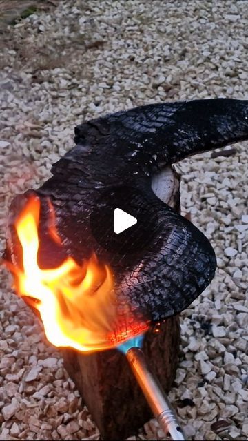 an open fire pit with flames coming out of it's sides and on top of rocks