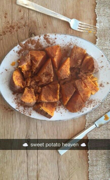 a white plate topped with food on top of a wooden table next to utensils