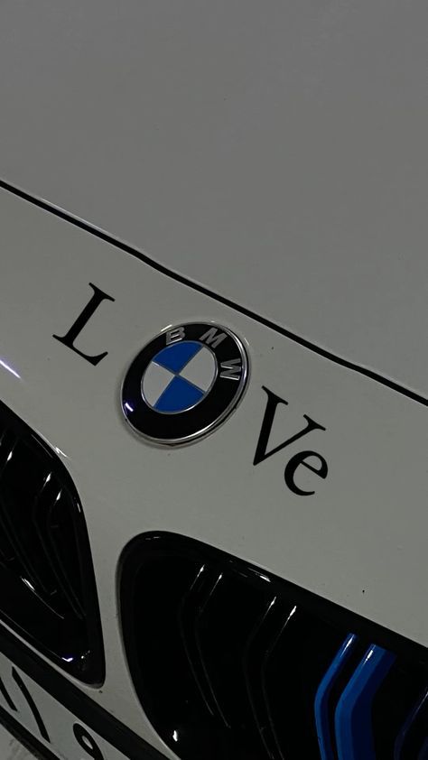 the front end of a white bmw car with love on it's grills