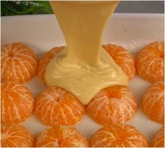 an orange being drizzled with cream over it's peeled fruit in a bowl