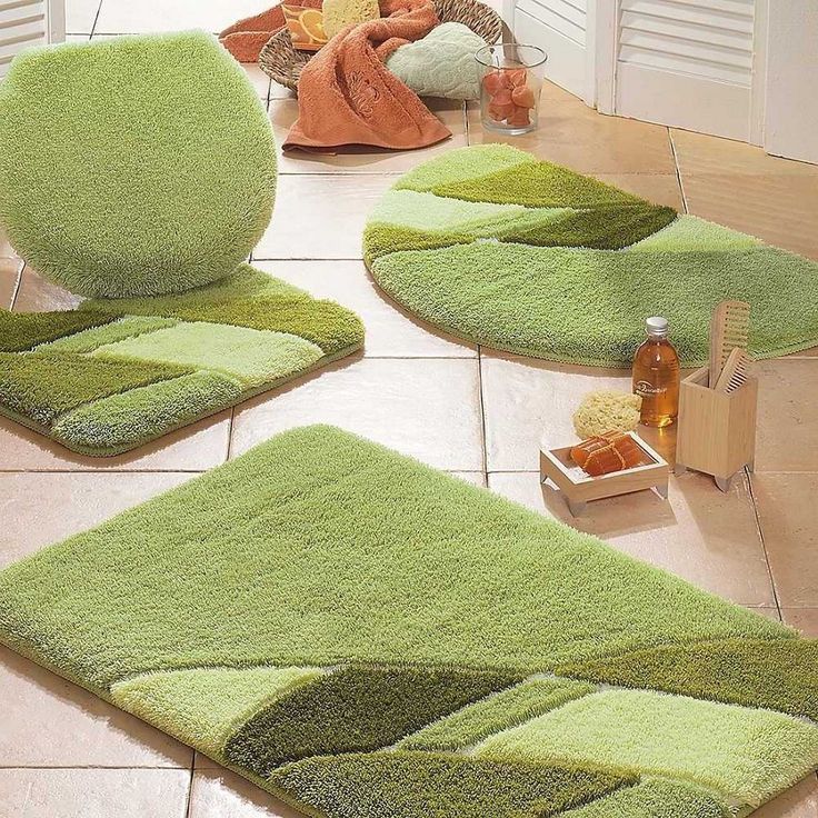 green bathroom rugs on the floor in front of a teddy bear and other items