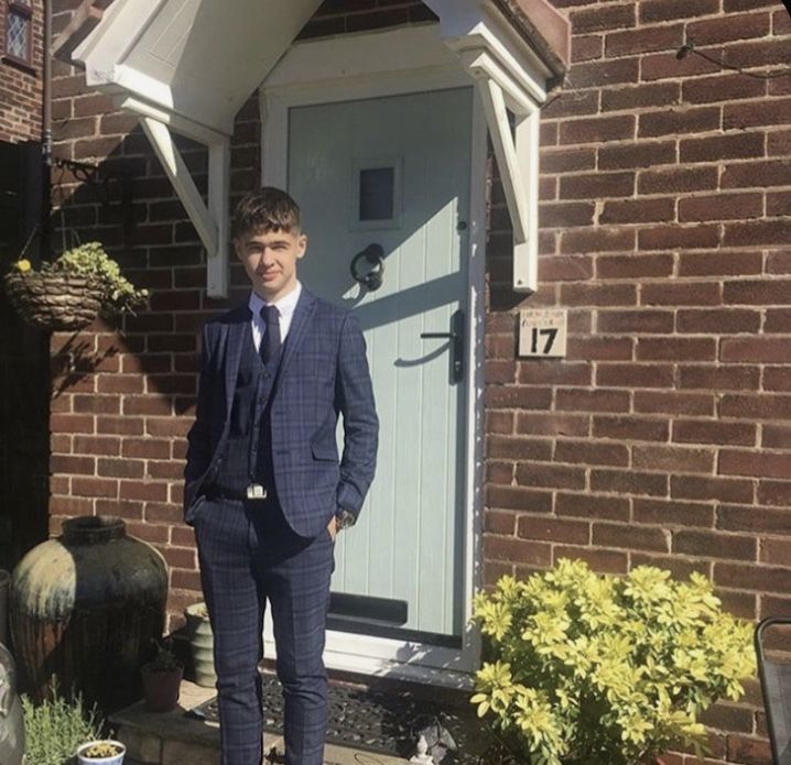 a man standing in front of a door wearing a suit and tie