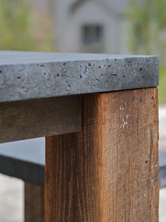 a wooden bench sitting on top of a cement and wood park bench next to a sidewalk