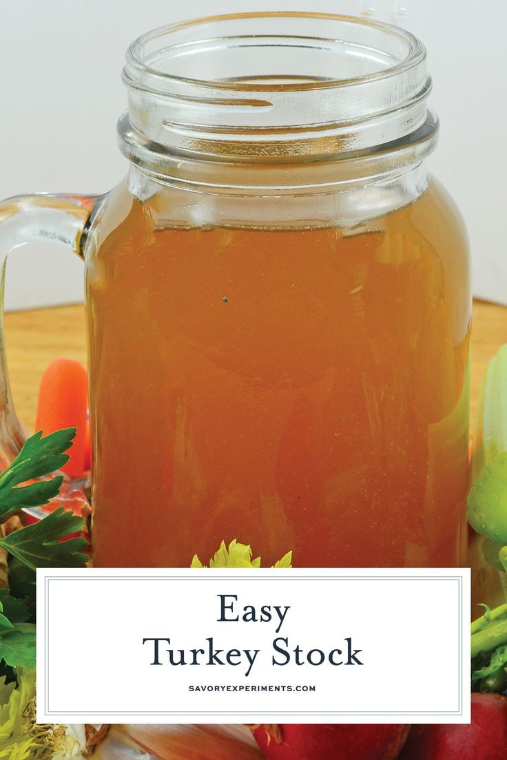 a glass jar filled with honey sitting on top of a table next to fruit and vegetables