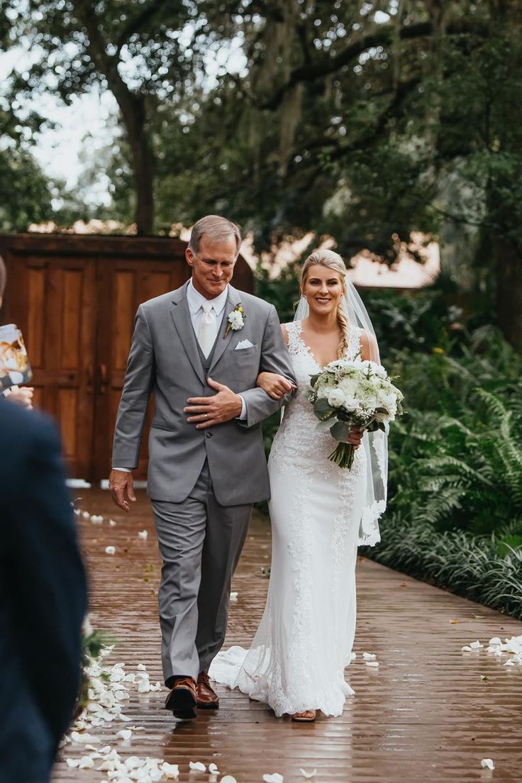 a bride and her father walking down the aisle at their outdoor wedding in charleston, ga