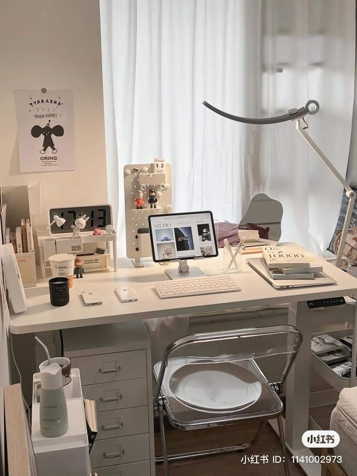 a desk with a laptop, keyboard and mouse on it in front of a window