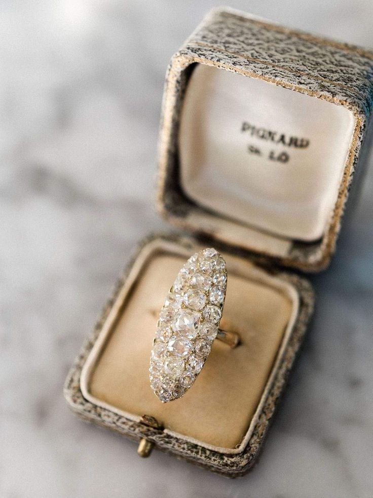 an antique diamond ring sits in its box