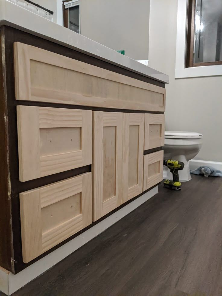 a bathroom with wood flooring and white walls