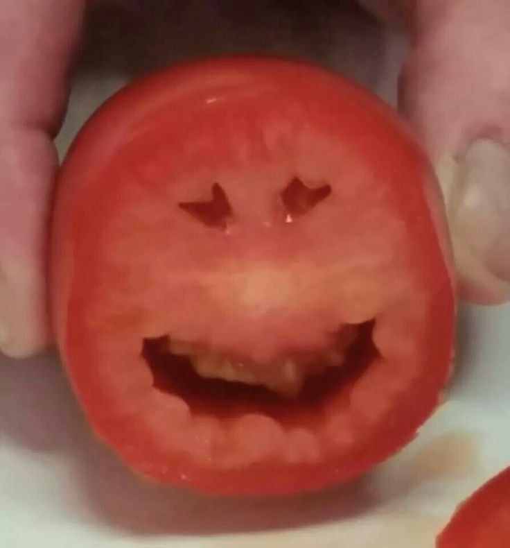 a close up of a tomato with a smile on it's face