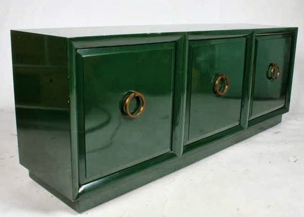 a green cabinet with two brass handles on the front and bottom, sitting against a white background