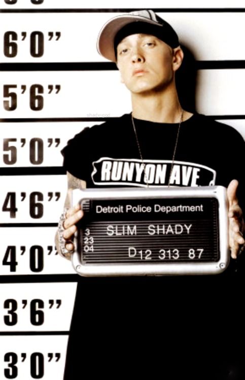 a man holding up a sign in front of a muggy mugshot wall with the words runyon avenue on it