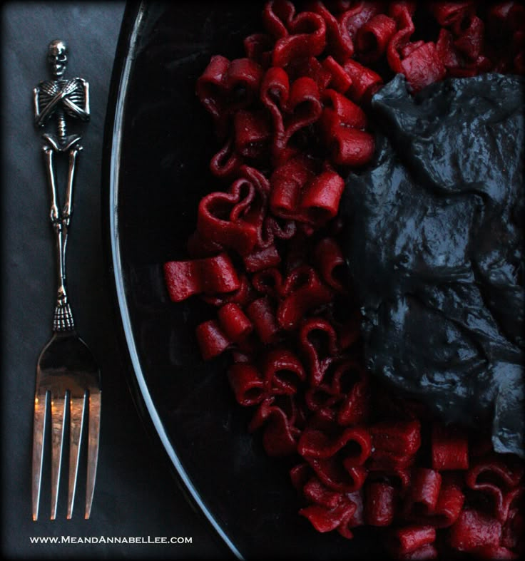 a plate filled with food next to a fork and skeleton figurine on the table