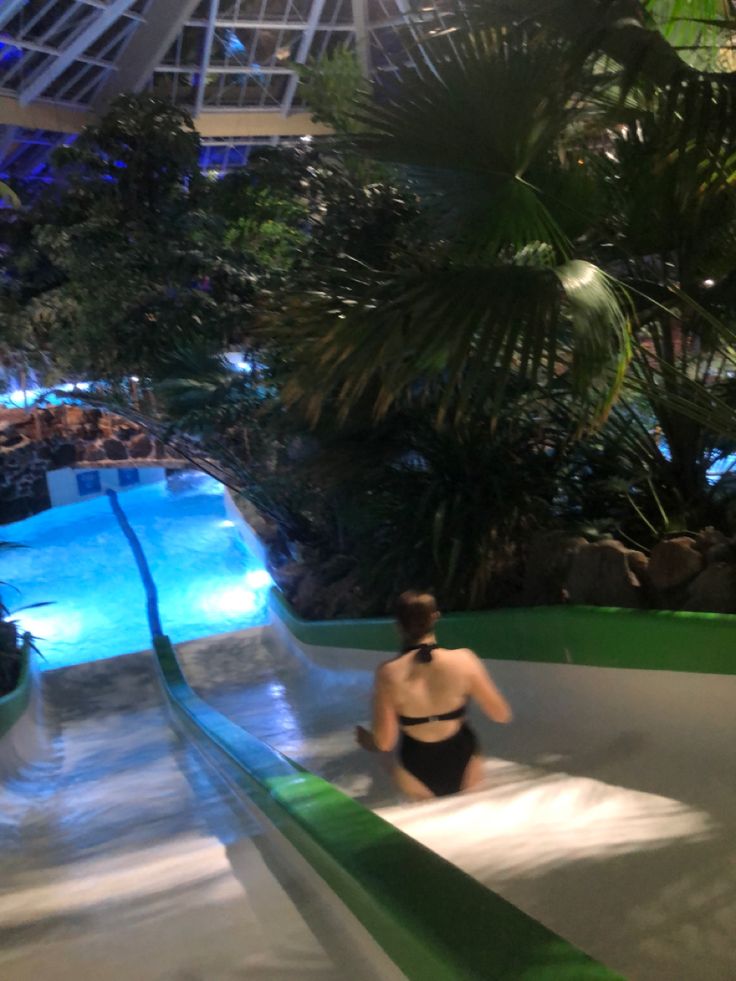 a woman in a bathing suit rides on an indoor water slide