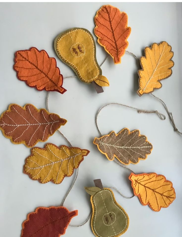 autumn leaves and acorns hanging from clothes pins on a white surface with text overlay