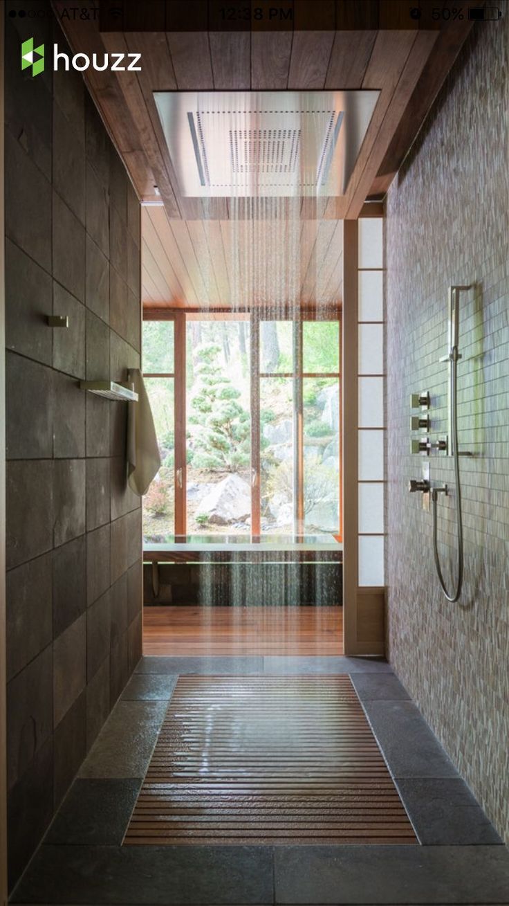 a bathroom with a large shower head and wooden walls, along with tiled flooring