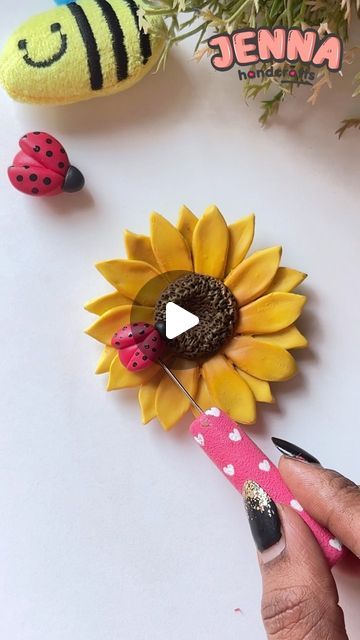 a ladybug pin sitting on top of a sunflower next to two stuffed animals