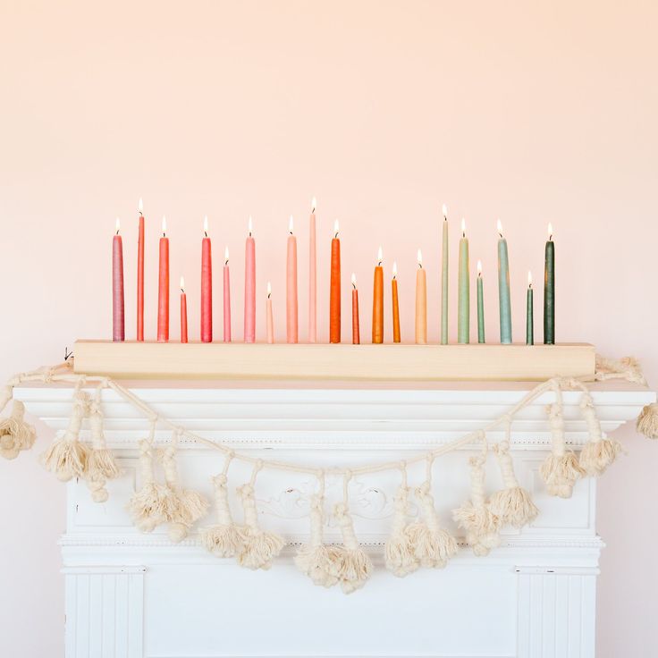 there are many candles on the mantle with tassels