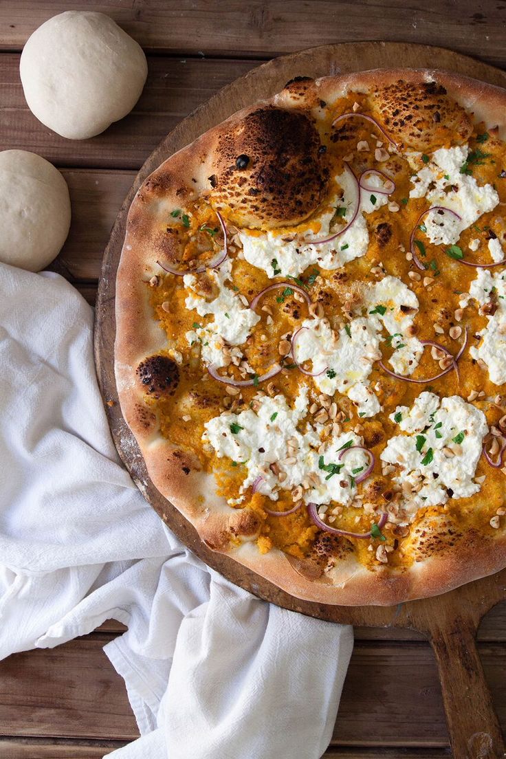 a pizza sitting on top of a wooden cutting board