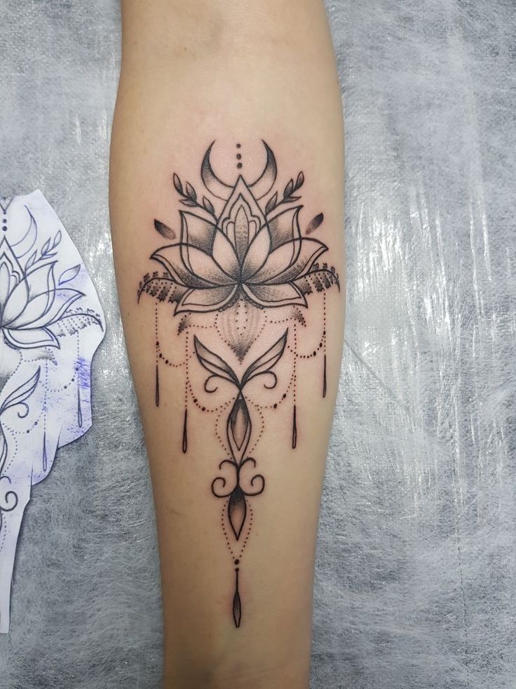 a woman's leg with a lotus tattoo on it