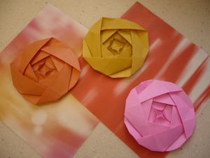 three different colored paper flowers sitting on top of each other