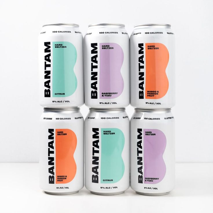 six cans of batman energy drink on a white table with an orange, pink, green and blue color scheme