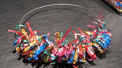 a circle made out of candy bars and streamers on a black surface with other items in the background