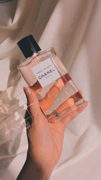 a person holding a bottle of chanel perfume