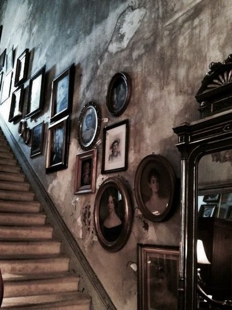 a staircase with many pictures on the wall and framed photos on the wall next to it