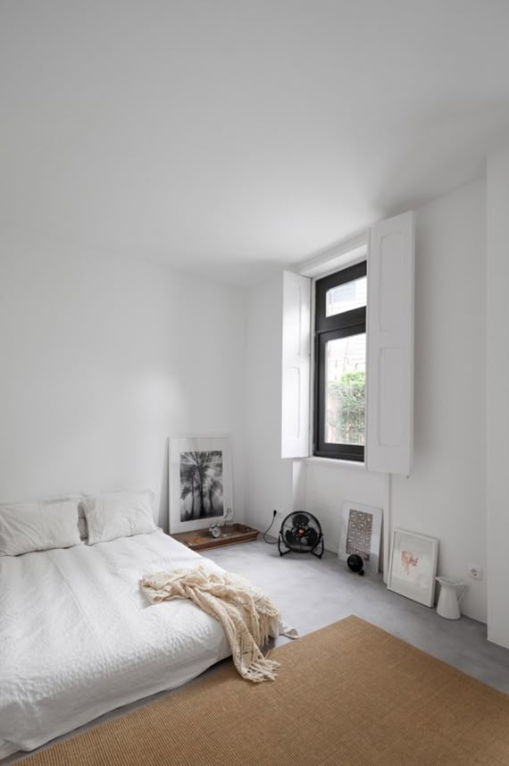 a bedroom with white walls and carpeted flooring has a large bed in the middle