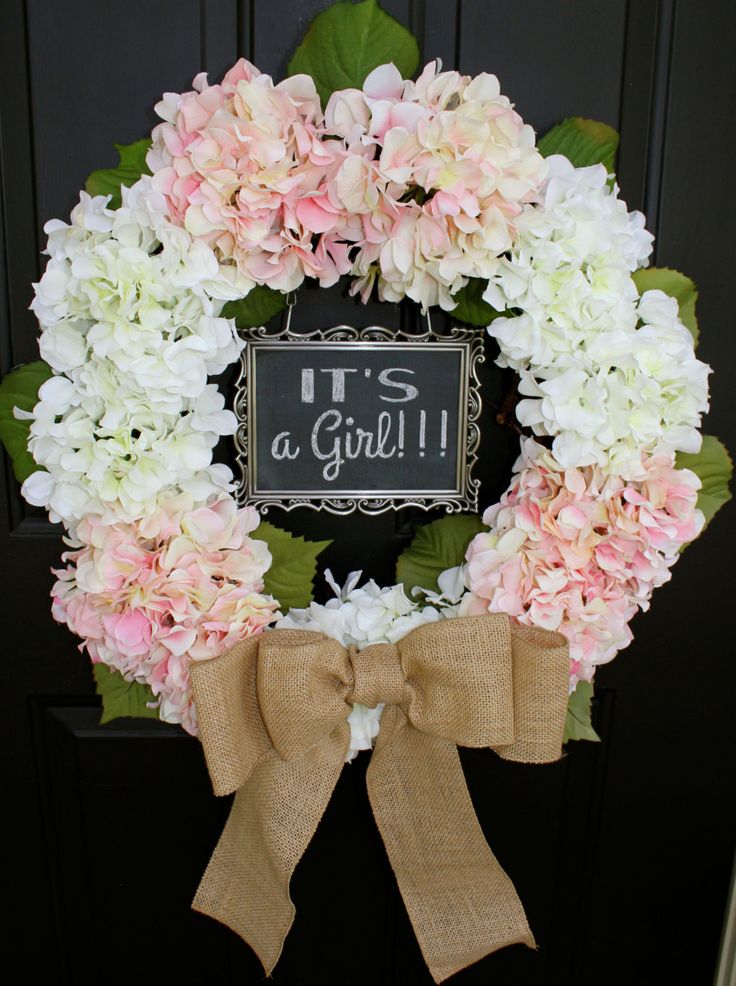 a pink and white wreath with it's a girl sign