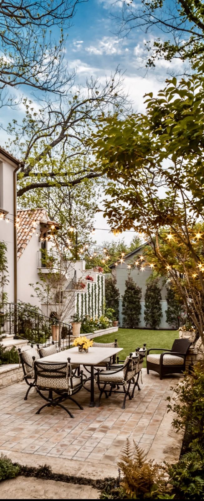 a patio with tables and chairs in front of a house