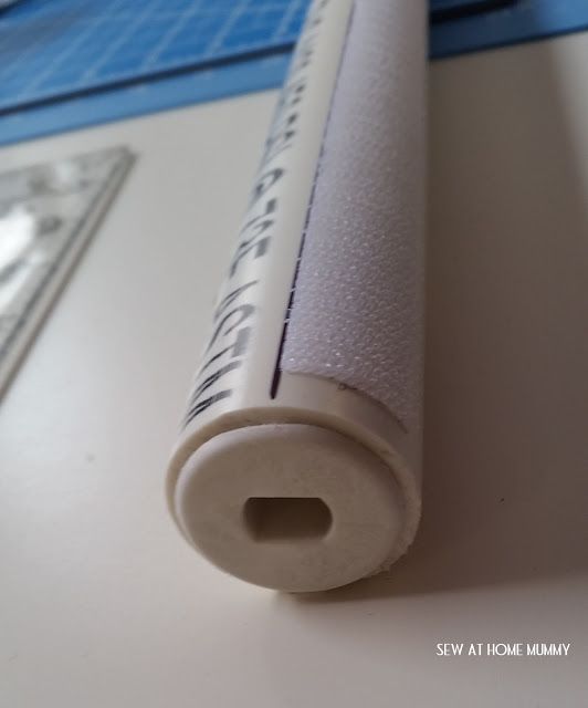 a close up of a white plastic tube on a table with a ruler in the background