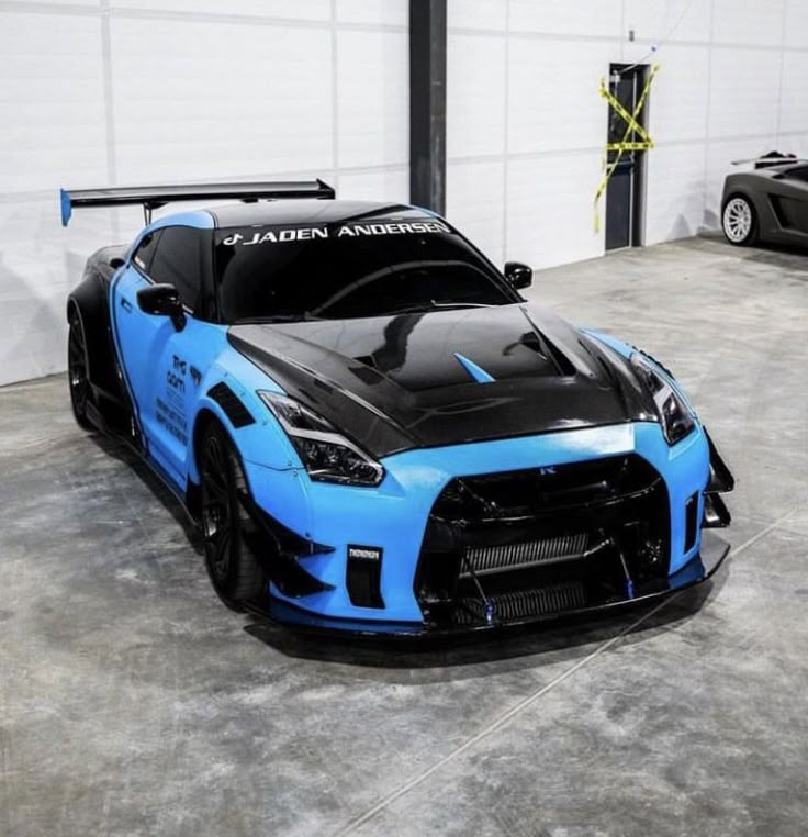 a blue and black sports car parked in a garage