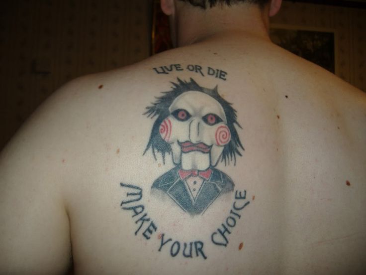 the back of a man's upper half with tattoos on his body and words that read live or die, save your choice