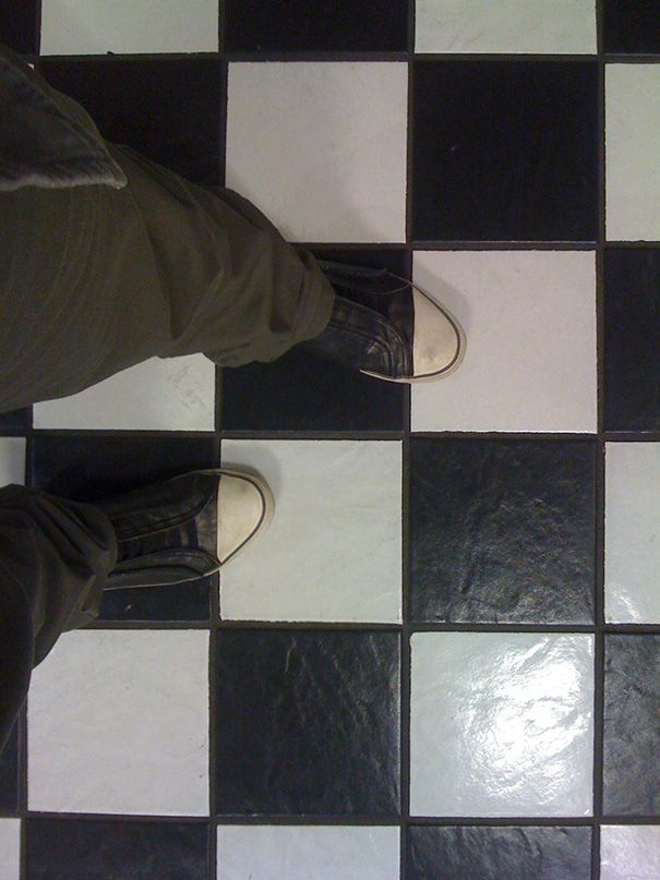 a person standing on a black and white checkered floor