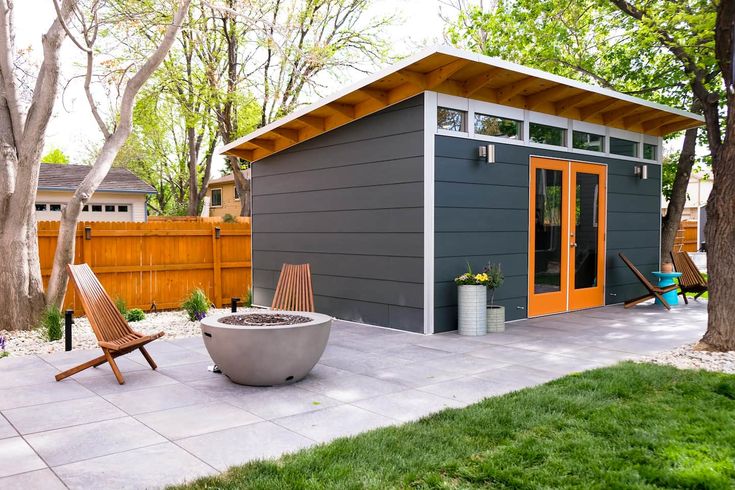 a small backyard with a fire pit in the middle and a shed on the other side