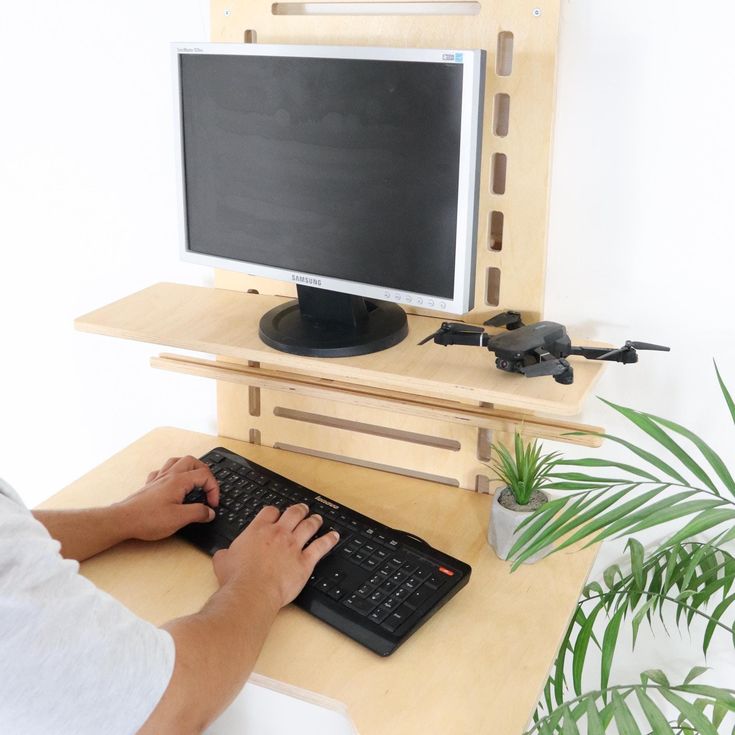 a person sitting at a desk with a keyboard and mouse in front of a monitor