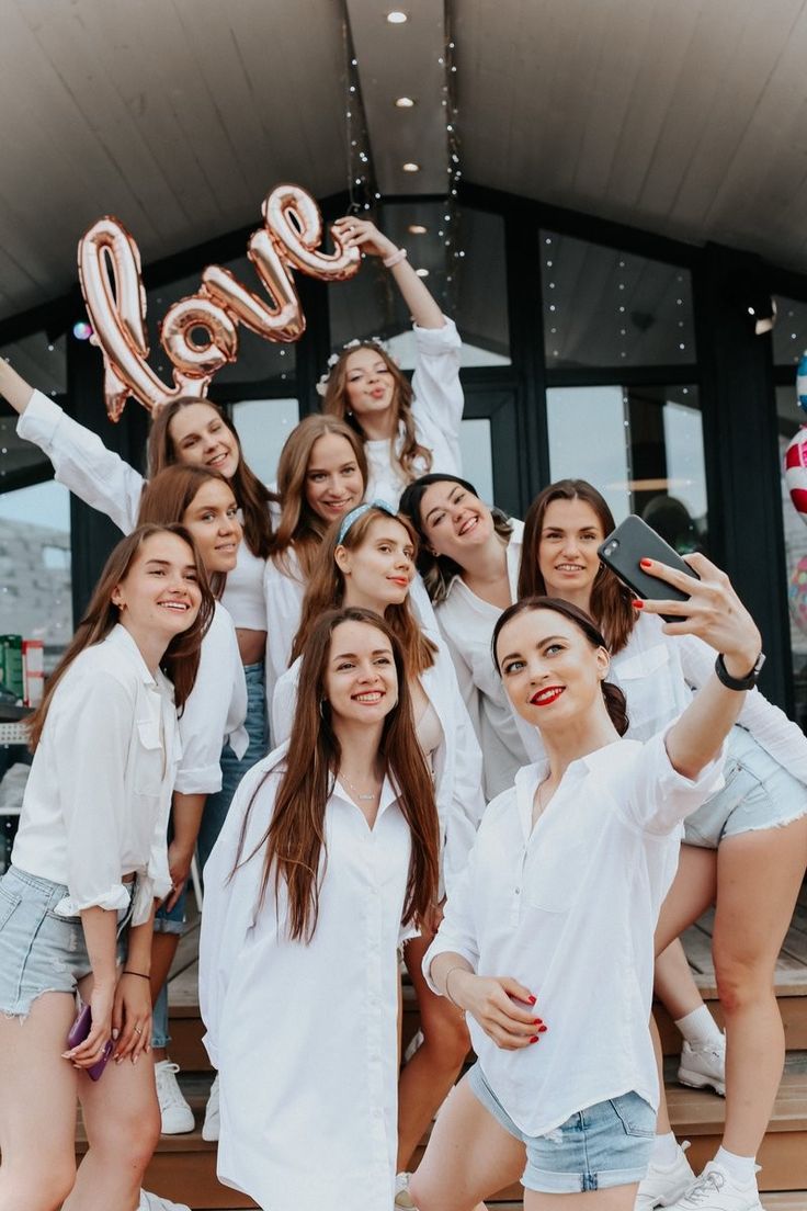 a group of young women standing next to each other in front of a sign that says love