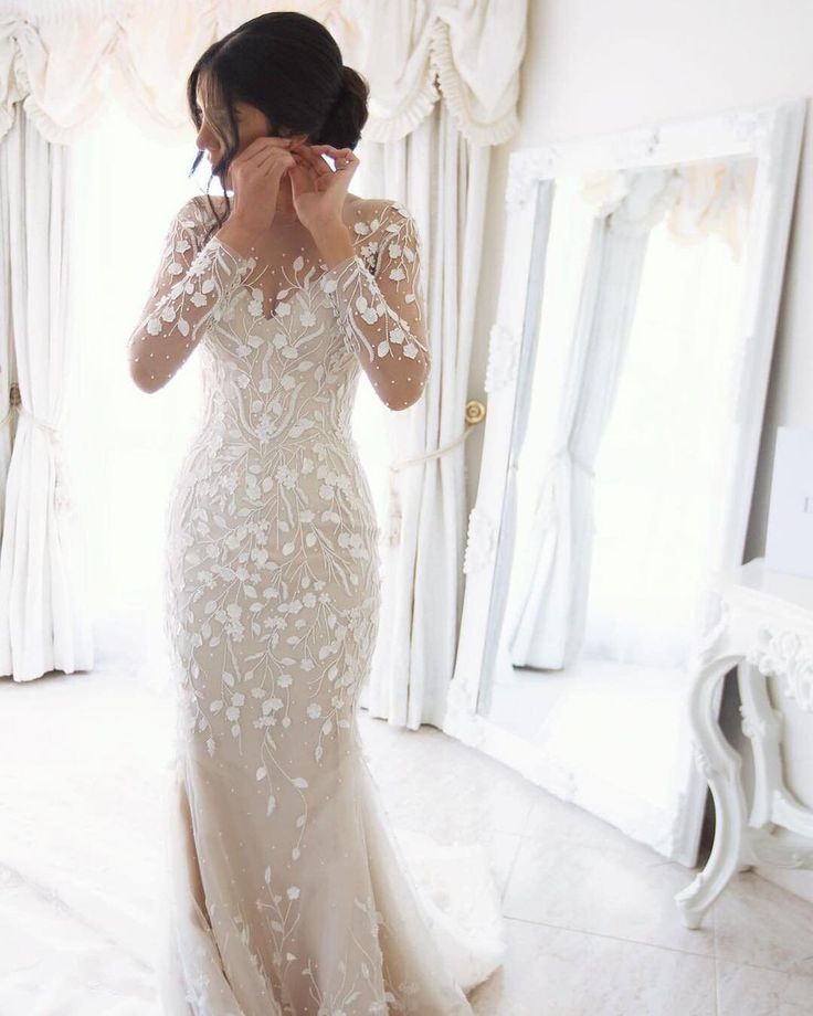 a woman in a wedding dress looking at herself in the mirror