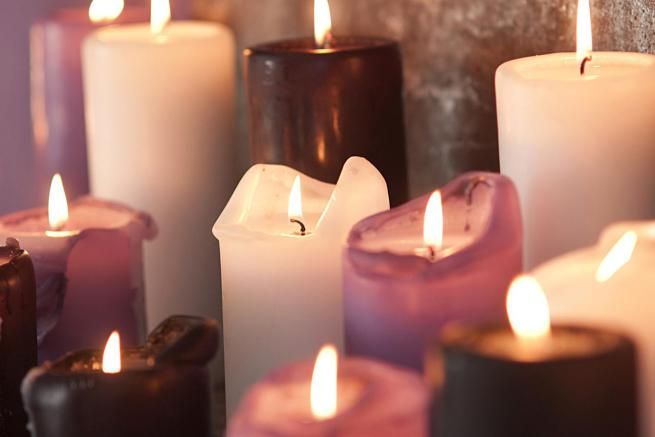 many lit candles sitting on top of a table