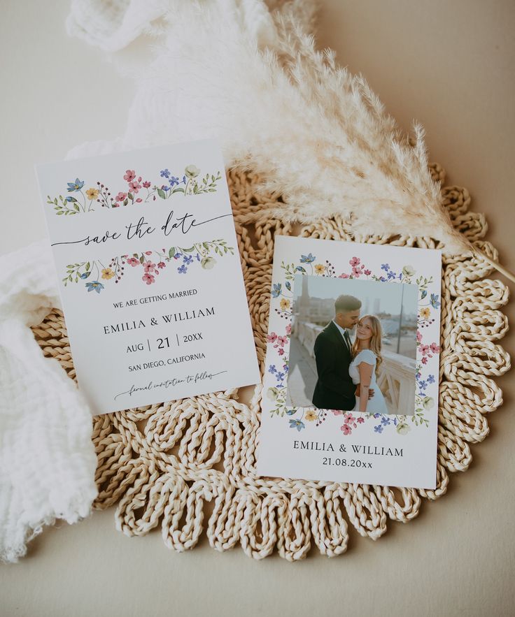 the wedding stationery is laid out on top of a doily with flowers and feathers