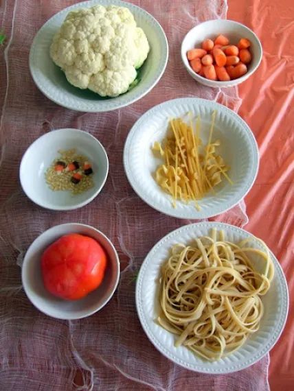 four bowls filled with different types of food on top of a pink cloth covered table